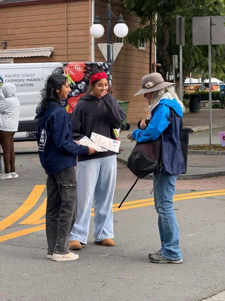 Team explaining robotics to a community member